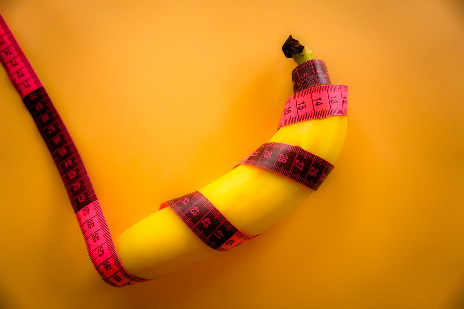 A banana wrapped with a tape measure to suggest measuring a small penis